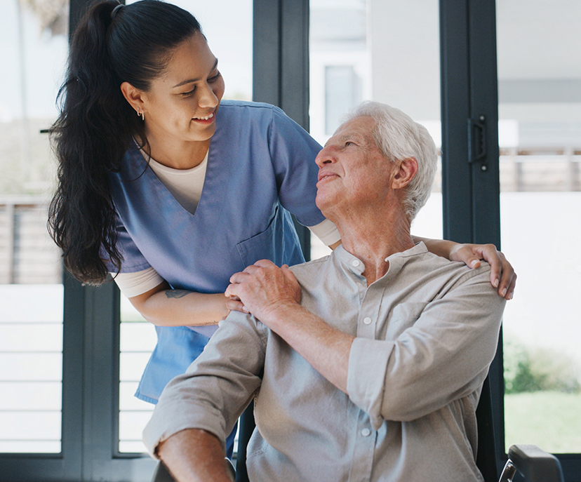 A woman nurse caring for an elderly man in a wheel chair.